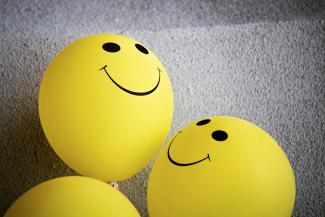 Two yellow balloons with smiley faces on them